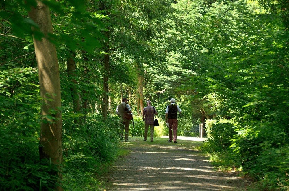 Customers walking down a path in the grounds of Lady's Wood Shooting School