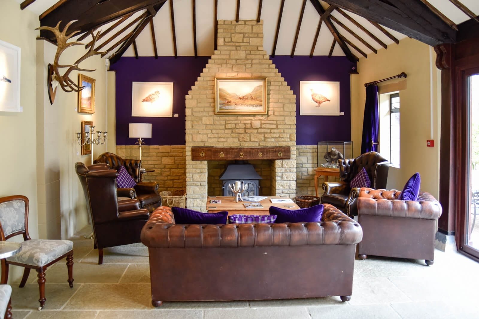 The fireplace and sofas in the meeting room at Lady's Wood Shooting School